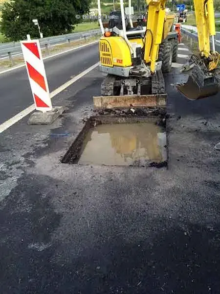 Tranchée ouverte et pelleteuse sur une route