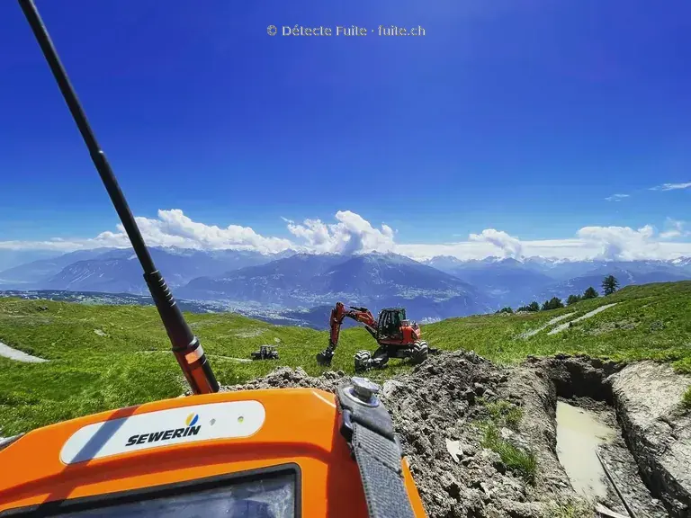 Appareil de détection Sewerin au premier plan d’un chantier de conduite en montagne